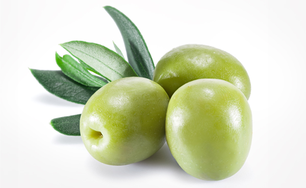 שלושה זיתים ירוקים ועלי זית לצדם